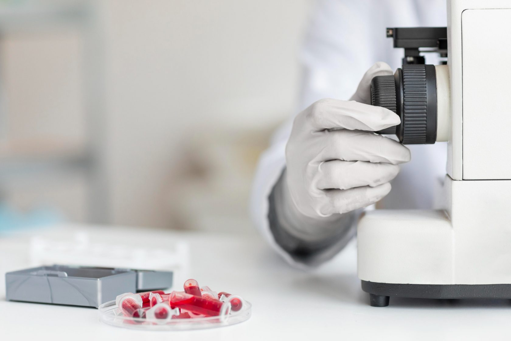 Une main règle un microscope