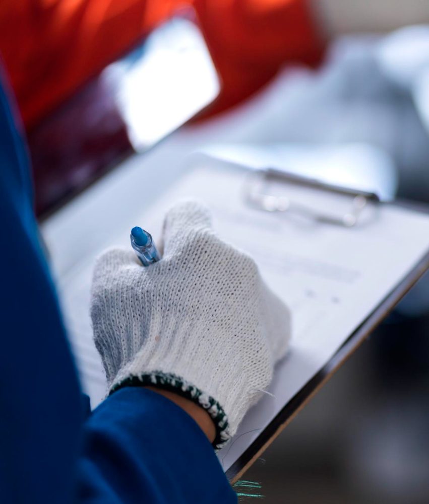 Une main écrit sur une plaquette